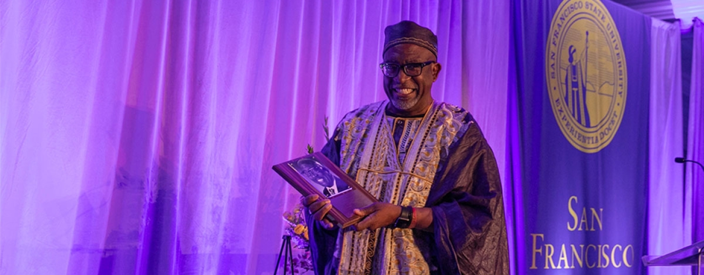Vincent Matthews proudly holds his plaque at the alumni Hall of Fame