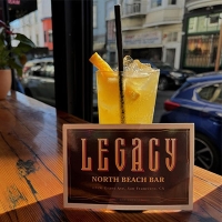 Drink with a promotional card about Legacy Bar 