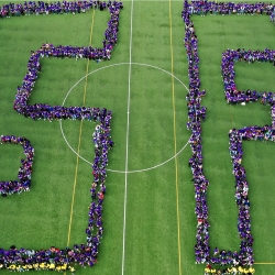 Students form the letters "SF" on the soccer field. 