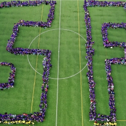 Students form the letters "SF" on the soccer field.